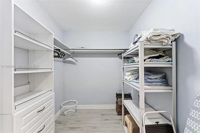 a view of walk in closet with clothes and shoes