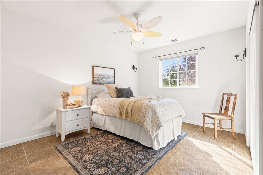 38 Lacewing Court Chico, CA 95973 - Photo 13 of 46 a bedroom with a bed and a chandelier