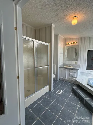 a room with stainless steel appliances kitchen island granite countertop a refrigerator and a sink