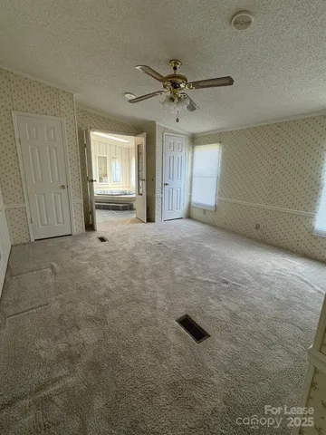 an empty room with windows and cabinet