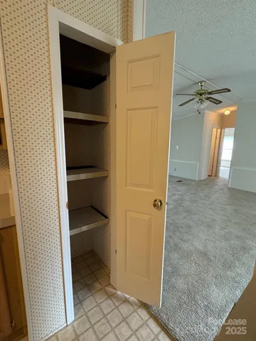 a view of a hallway with closet and a window