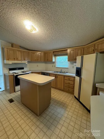 a kitchen with stainless steel appliances granite countertop a sink and a refrigerator