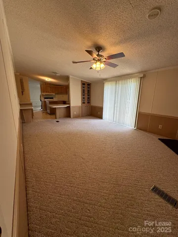 a view of a livingroom with furniture a ceiling fan and window