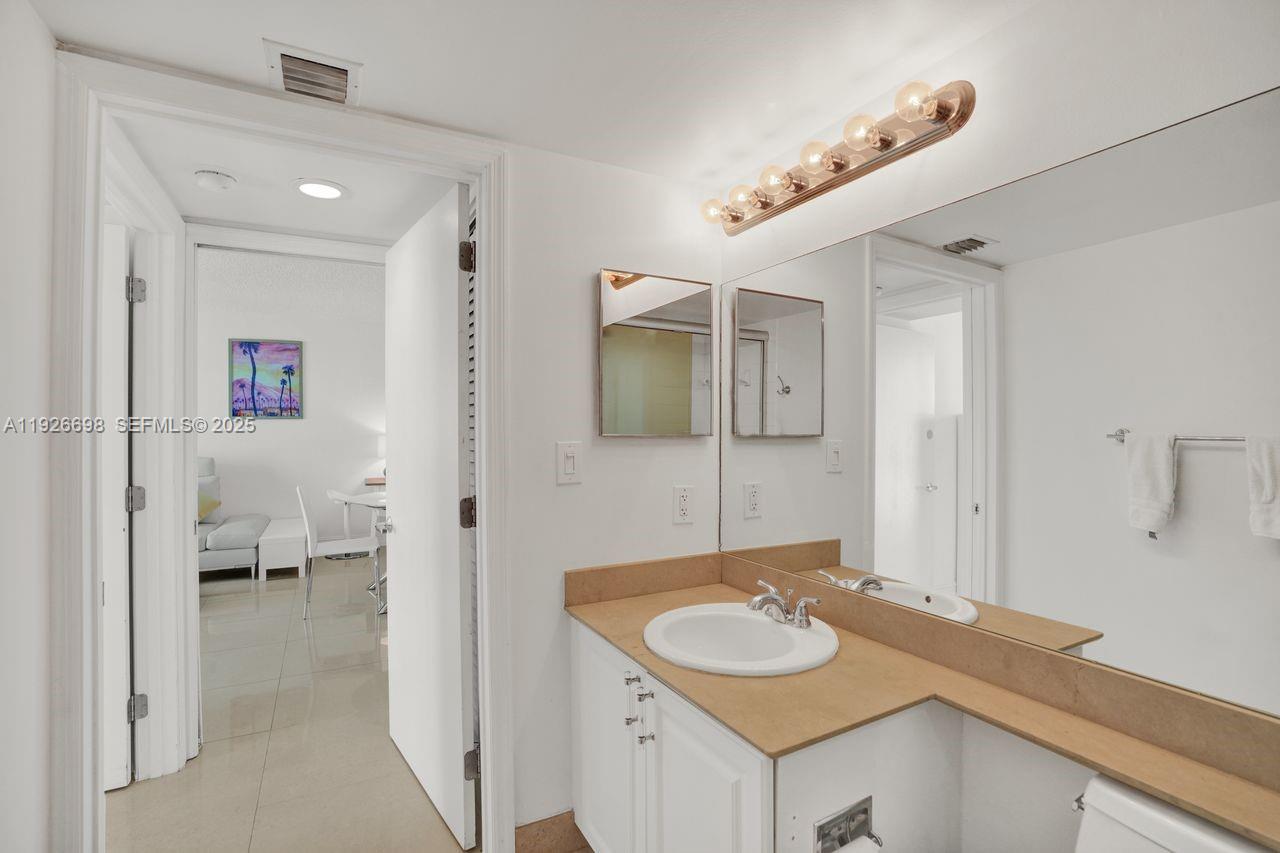 90 Alton Road, Unit 2907 Miami Beach, FL 33139 - Photo 20 of 42 a en suite bathroom with a sink and a mirror