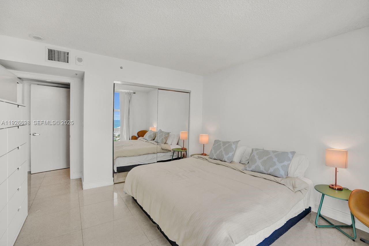 90 Alton Road, Unit 2907 Miami Beach, FL 33139 - Photo 28 of 42 a bedroom with a bed and a lamp