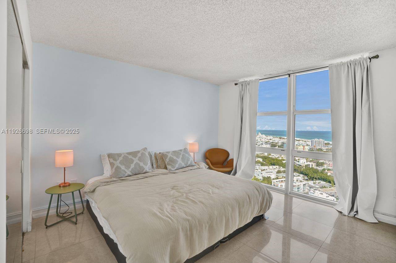 90 Alton Road, Unit 2907 Miami Beach, FL 33139 - Photo 6 of 42 a bedroom with a large bed and a window