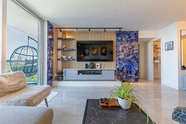 a living room with furniture a flat screen tv and a fireplace