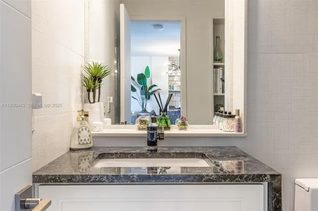 a bathroom with a sink toilet a mirror and shower