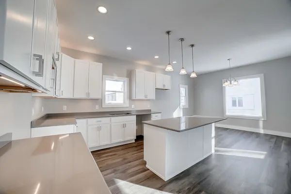 a kitchen with granite countertop a sink and wooden floor