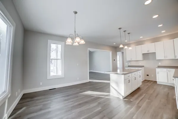 an empty room with wooden floor ceiling fan and windows