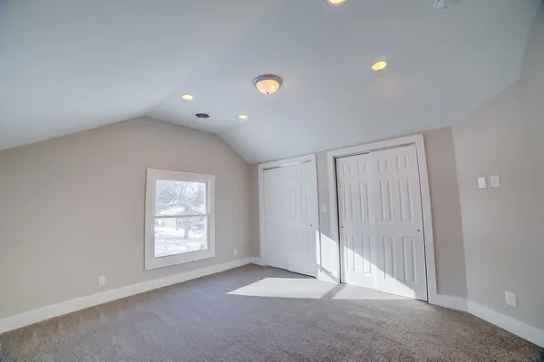 an empty room with windows and closet