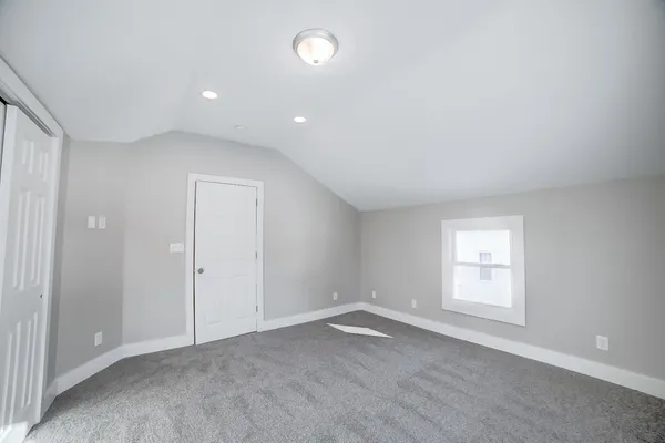 a view of an empty room with a window and a ceiling fan