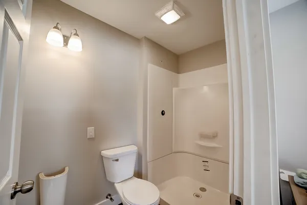 a bathroom with a toilet a sink and shower