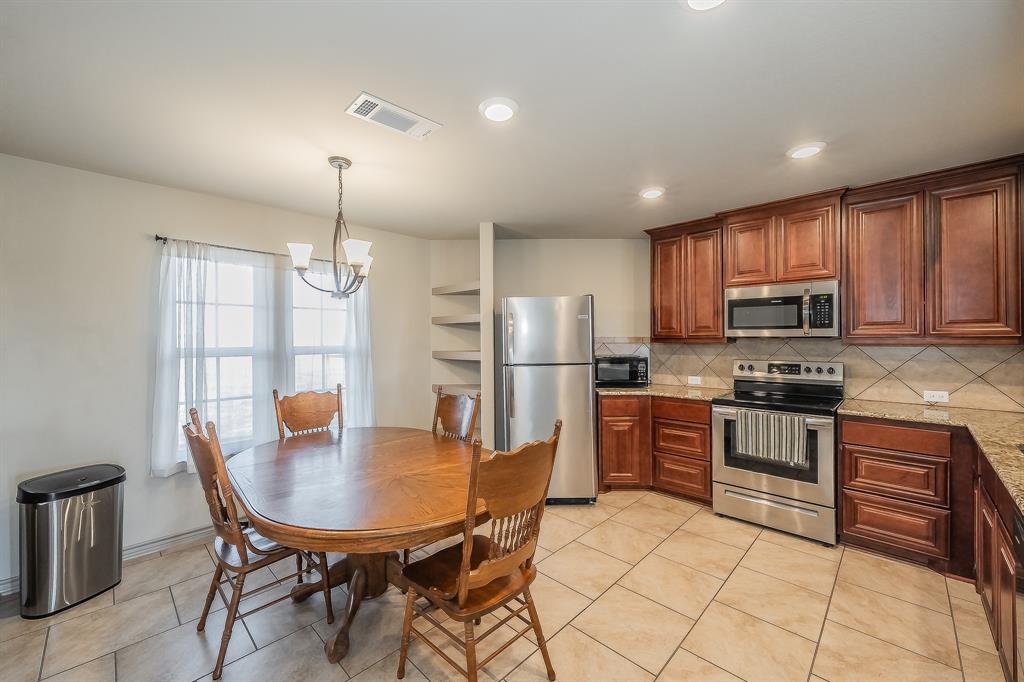 2376 Farm To Market Road 2264 Decatur, TX 76234 - Photo 22 of 39 a kitchen with stainless steel appliances granite countertop a stove a refrigerator a kitchen island a table and chairs