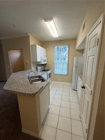 a kitchen with granite countertop a sink and a stove top oven
