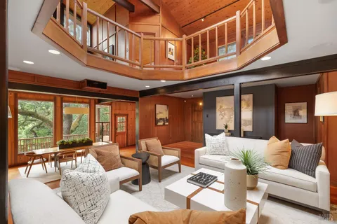 a living room with furniture a fireplace and large windows