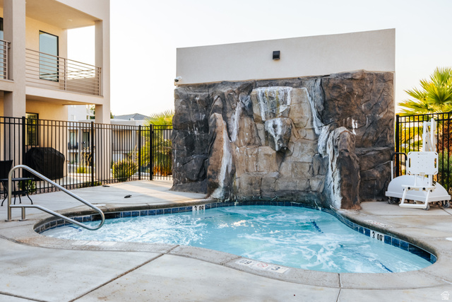 1122 South 1790th West, Unit 1 St. George, UT 84770 - Photo 33 of 37 Bubbling spa featuring a rock waterfall, surrounding concrete patio, and dark tile border
