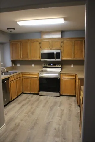a kitchen with a stove sink and cabinets