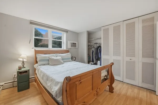 a bedroom with a bed and a flat tv screen on the dresser