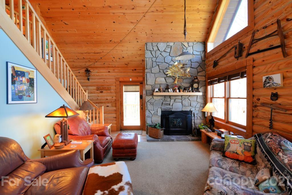 175 Owl Lookout Sylva, NC 28779 - Photo 9 of 20 a living room with furniture a fireplace and a floor to ceiling window