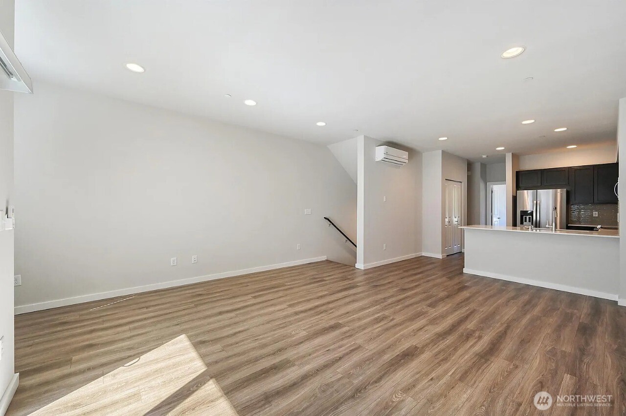 13117 3rd Avenue Southeast, Unit D5 Everett, WA 98208 - Photo 6 of 22 a view of an empty room with wooden floor and a window