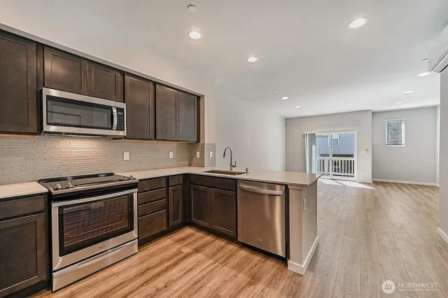 a kitchen with stainless steel appliances granite countertop wooden cabinets and a stove top oven