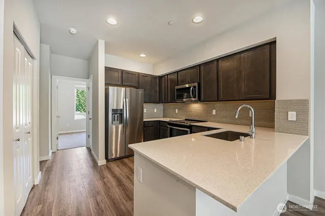 a kitchen with stainless steel appliances a refrigerator sink and wooden cabinets