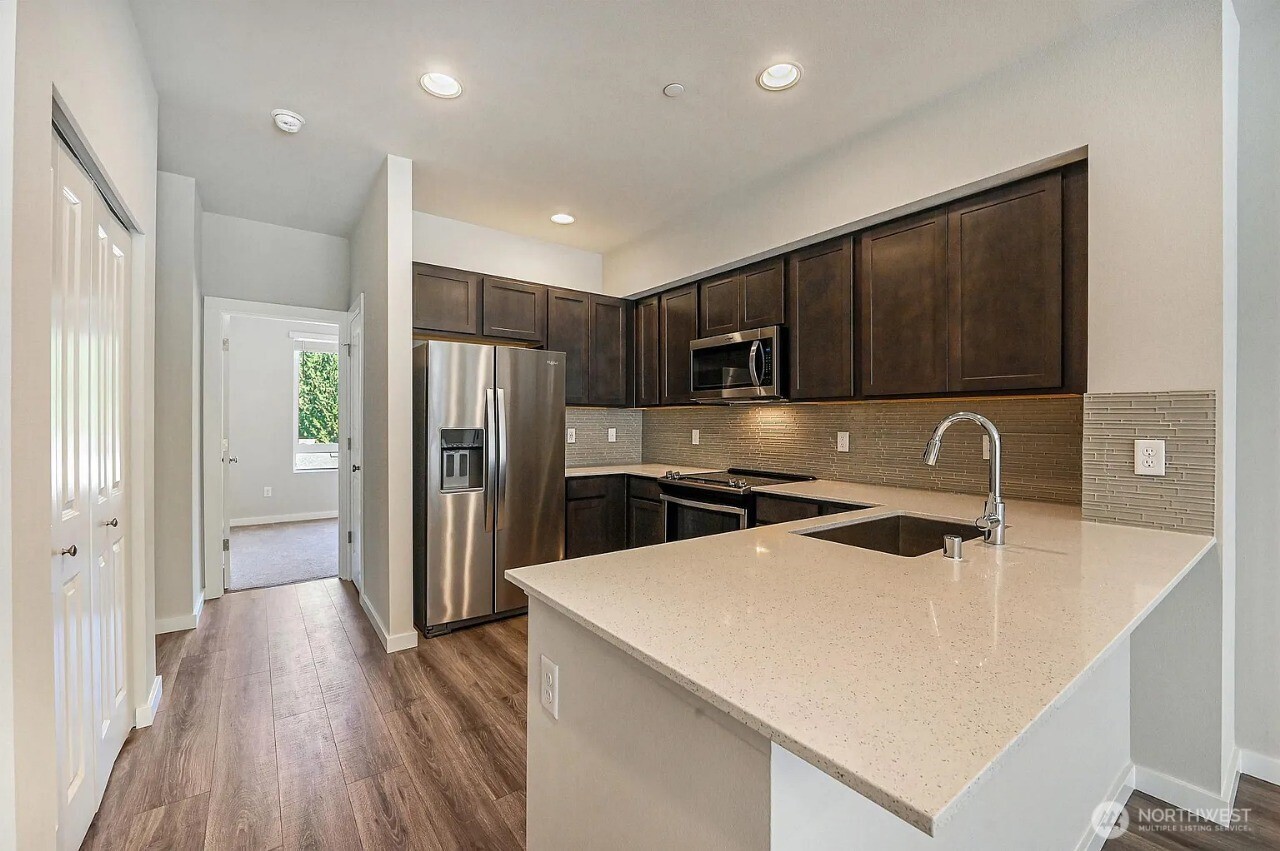 13117 3rd Avenue Southeast, Unit D5 Everett, WA 98208 - Photo 9 of 22 a kitchen with stainless steel appliances a refrigerator sink and wooden cabinets