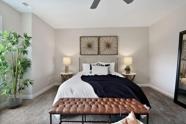 a bedroom with a bed and a potted plant