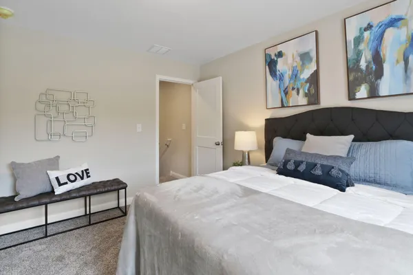 a spacious bedroom with a bed and painting on the wall