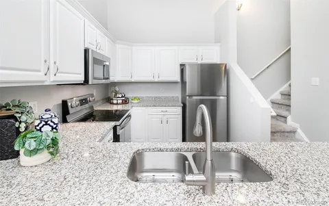 a kitchen with granite countertop a sink a stove and a granite counter top
