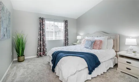 a bedroom with a bed and a potted plant