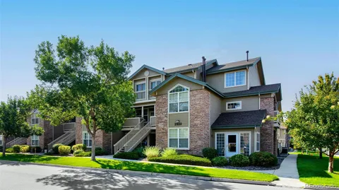 a front view of a house with a yard and potted plants