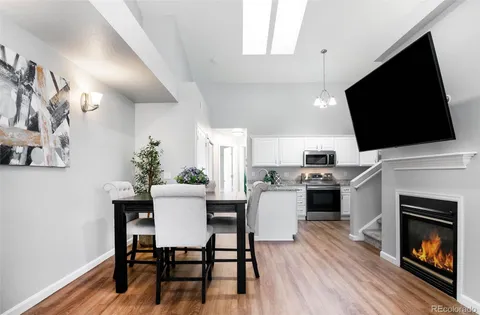a view of a dining room with furniture wooden floor and a fireplace