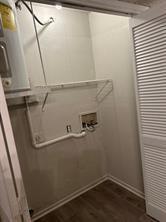 11490 Audelia Road, Unit 127 Dallas, TX 75243 - Photo 3 of 3 Utility area featuring wood-finish flooring, a water heater, and a bi-fold louvered door