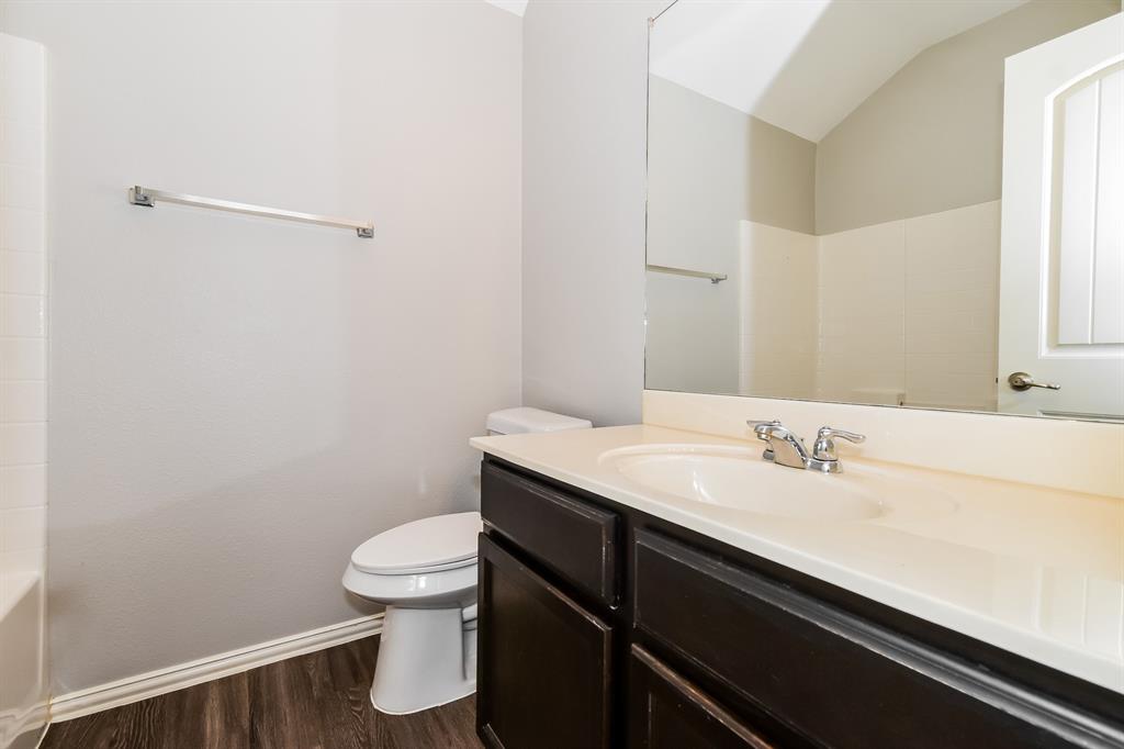 1821 Ridgecrest Drive Terrell, TX 75160 - Photo 16 of 18 a bathroom with a sink a toilet and a mirror