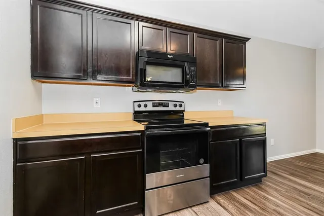 a kitchen with wooden cabinets and stainless steel appliances