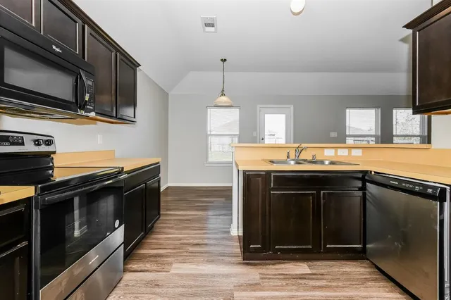 a kitchen with stainless steel appliances granite countertop a stove and a microwave