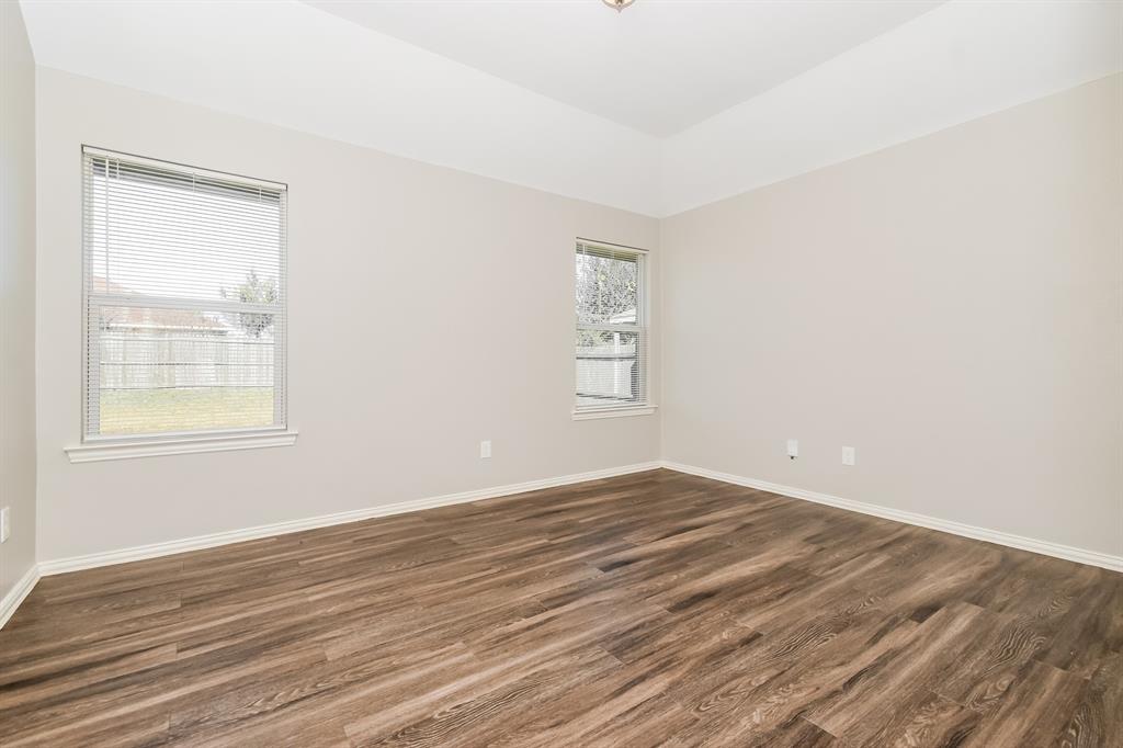 1821 Ridgecrest Drive Terrell, TX 75160 - Photo 9 of 18 an empty room with wooden floor and windows