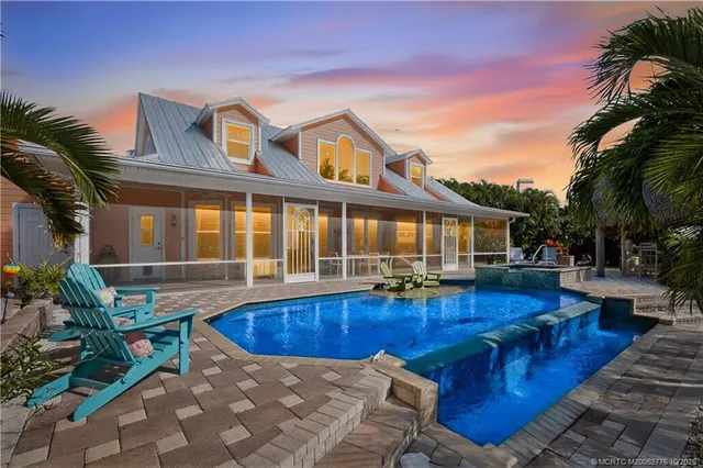 a view of a house with swimming pool and sitting area