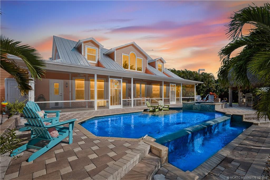 a view of a house with swimming pool and sitting area