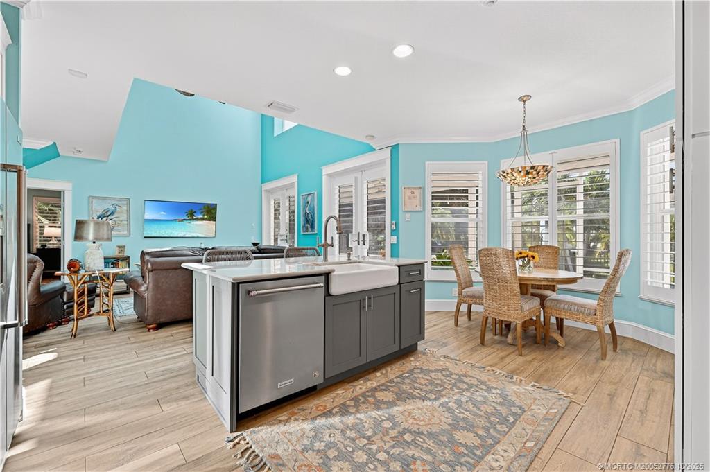802 Southeast Portage Avenue Port St. Lucie, FL 34984 - Photo 19 of 48 a kitchen with stainless steel appliances granite countertop a stove a sink dishwasher and a dining table with wooden floor