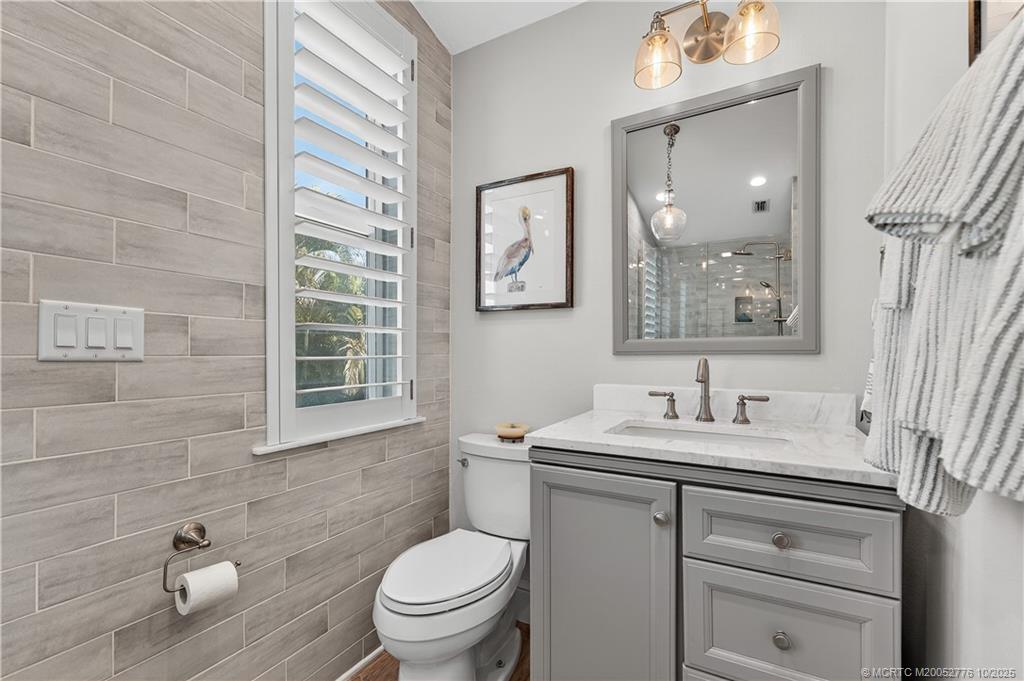 802 Southeast Portage Avenue Port St. Lucie, FL 34984 - Photo 31 of 48 a bathroom with a toilet sink and mirror