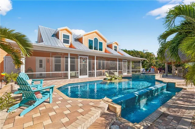 a view of a house with swimming pool and sitting area
