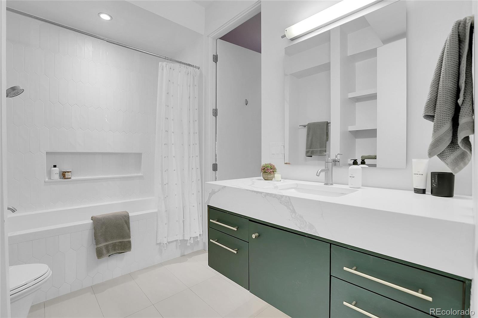 3131 Zuni Street, Unit 302 Denver, CO 80211 - Photo 20 of 36 a bathroom with a sink a toilet and a mirror