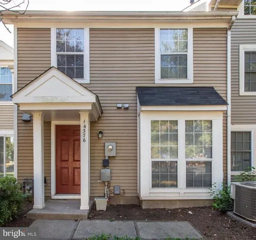 a front view of a house with a tree