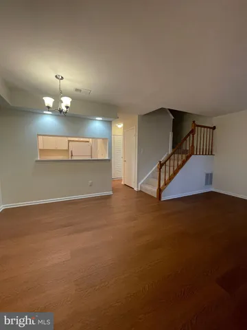 a view of an empty room with a chandelier fan
