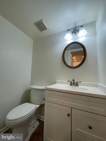 a bathroom with a granite countertop toilet sink and mirror