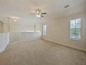 en empty room with windows and fan