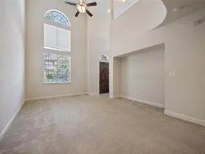 an empty room with a ceiling fan and a window